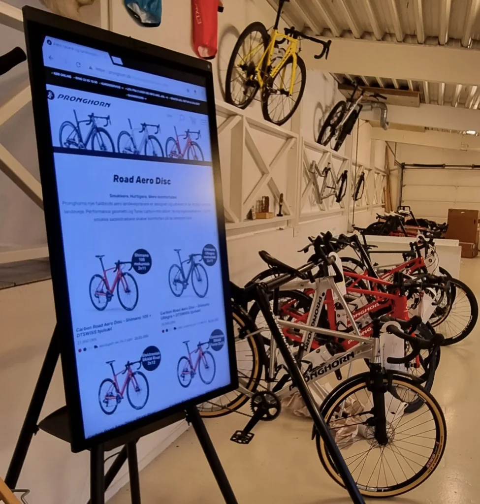 Et i3 sixty interaktiv whiteboard med billeder af cykler står i en cykel butik